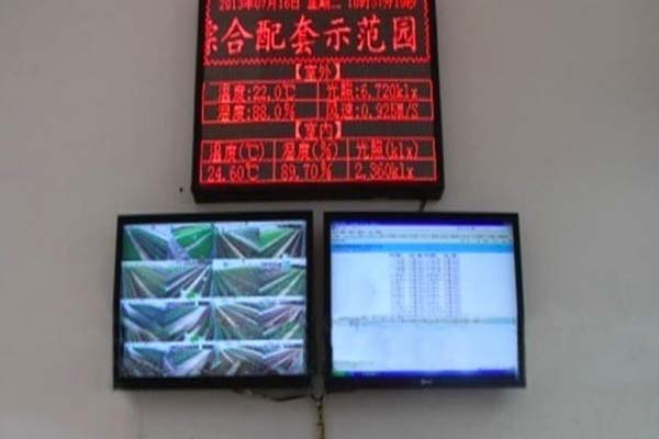 Greenhouse control display board and monitoring screens showing climate readings